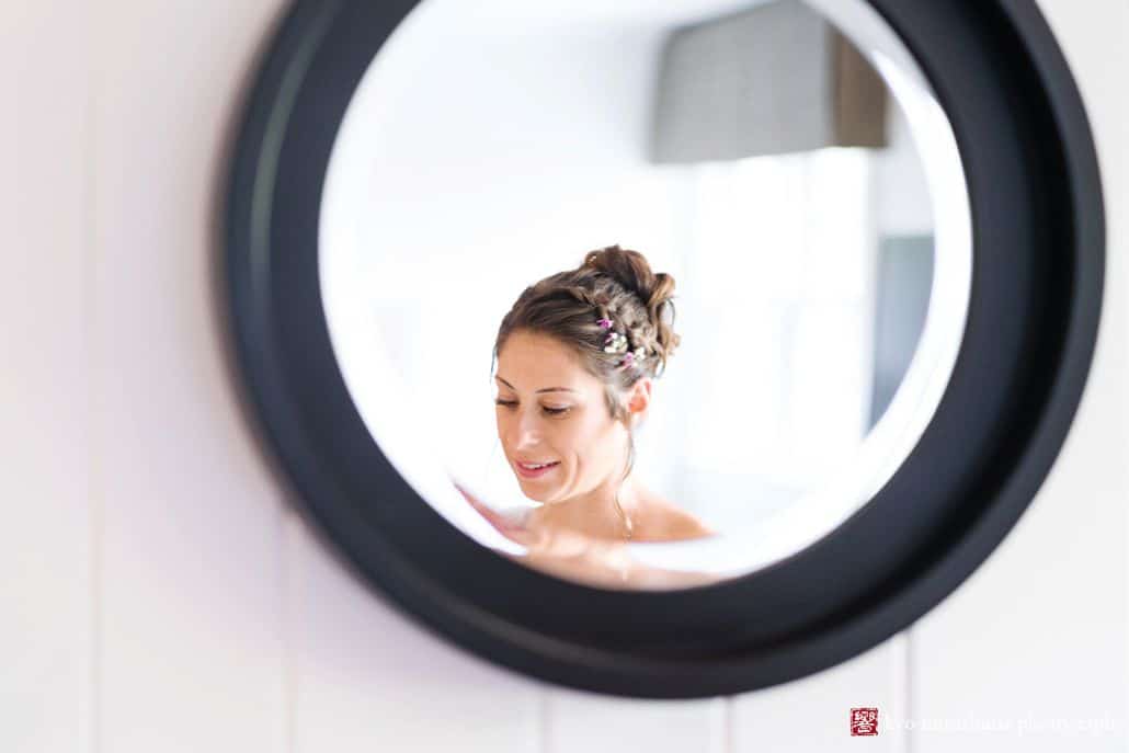 Bride at a Chauncey Center wedding is in her Laurie House hotel room getting ready for the big reveal with her hair in a loose up do with flowers.