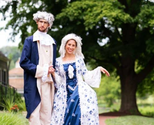 Bride and groom in period costume -- Revolutionary War era formal coat, hoopskirt, and wigs -- at Chauncey Center wedding in Princeton.