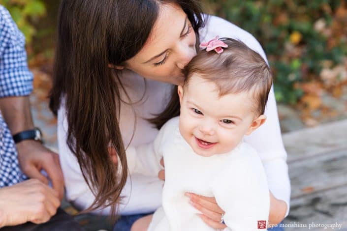 Mom kisses baby during fun, candid fall family portrait session in Princeton, NJ