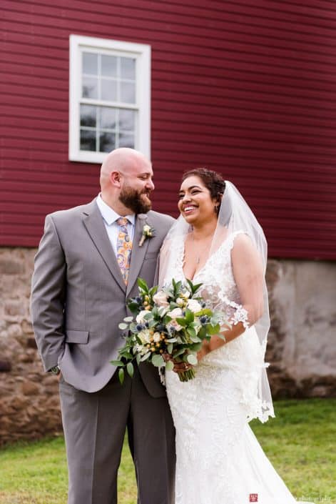 Candid wedding photographer NJ: relaxed portrait in front of the red barn at Glenmoore Farm in Hopewell NJ