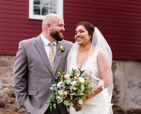 Candid wedding photographer NJ: relaxed portrait in front of the red barn at Glenmoore Farm in Hopewell NJ