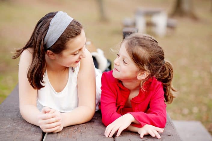 Sisterly love. Family portraits outside, in the park. Relaxed, candid New Jersey family photography.