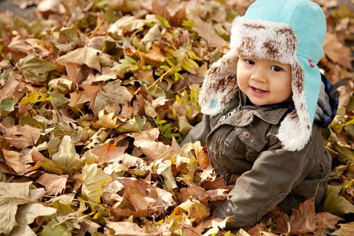 Fall family photo shoot, baby boy playing in the leaves. NYC child and family photography.