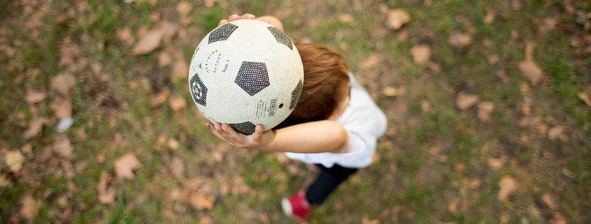 Natural family playing soccer outside. NYC child and family photography.