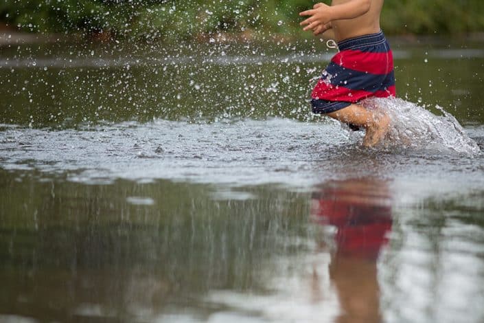 Natural family, son splashing in the lake. NYC child and family photography.