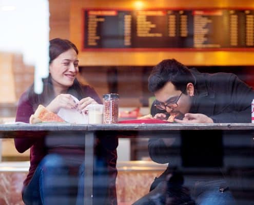 NYC casual engagement photo at classic pizza joint on the Upper West Side