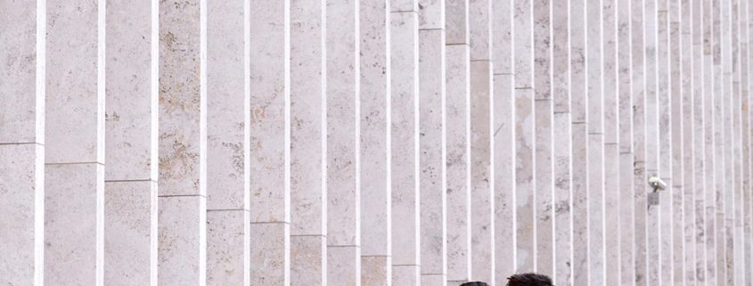 Lincoln Center engagement photo in NYC with monochromatic wall in the background