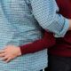 Close-up of couple hugging each other (no faces); man wearing blue checked shirt, woman wearing burgundy sweater. Engagement photo detail shot in Brooklyn, NY.