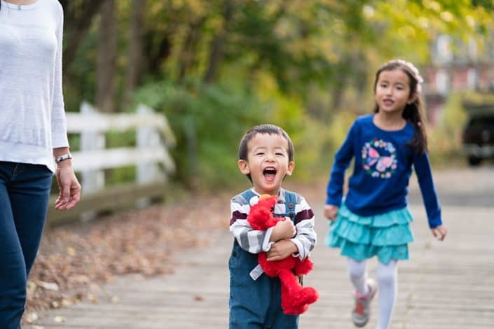 Brother and sister running and playing together at the park. Natural, candid child and family portraits. New Jersey family photography.