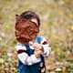 a boy covering his face with a big leaf Princeton family portrait photo