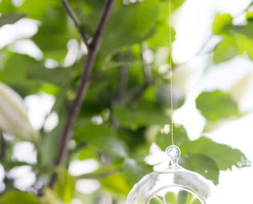 Glass globe hanging flowers as wedding decor idea: simple and stylish