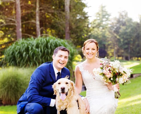 Bride and groom pose outside with their dog golden retriever at Woodloch Pines resort, white and pale peach bouquet with burgundy accents by Fox Hill Farm Experience, Castle Couture wedding gown, cobalt blue groom's suit, outdoor poconos wedding photographer., Woodloch Pines wedding, cute wedding pictures