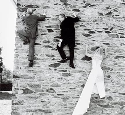 Bride, groom and bestman climbing up stone wall building Pennsylvania PA outdoor rock climbers wedding