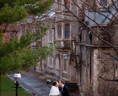 winter Princeton University campus wedding bride & groom newlyweds portrait holding hands kiss dusk architecture