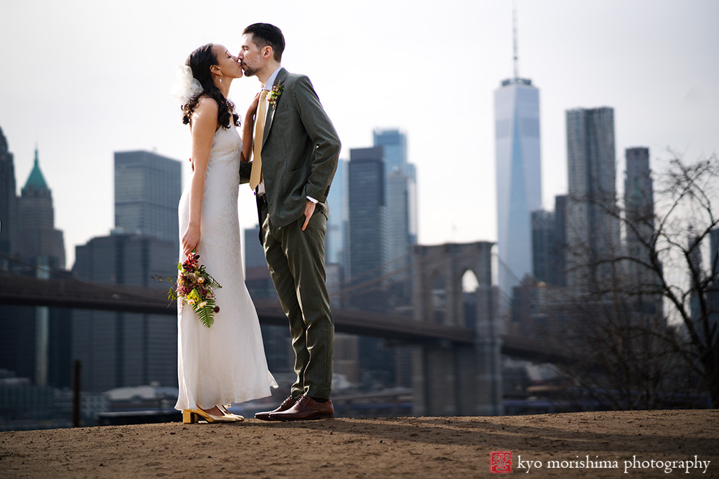 Vinegar Hill House, Dumbo Brooklyn, NYC, bride and groom, newlyweds outdoor street portrait in front of Brooklyn Bridge World Trade Center and East River kiss