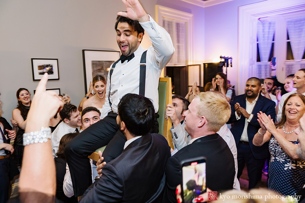 Groom on chair up in the air wedding reception at Princeton Prospect House & Garden
