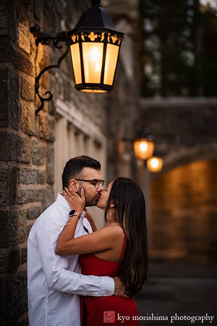 Princeton University Campus Firestone Library NJ canded documentary engagement portrait session fall autumn a couple red dress European brick building wooded door street lights hold each other hug kiss
