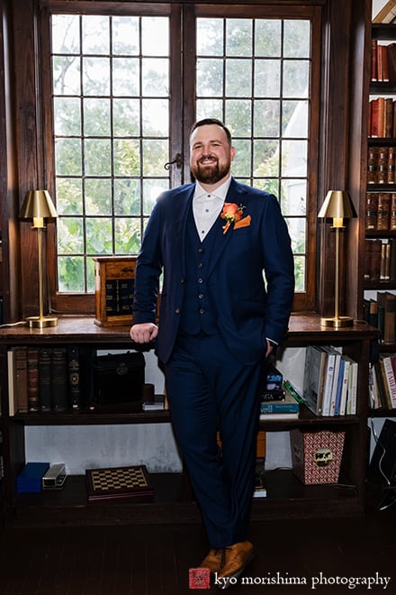 at Fall The Inn at Fernbrook Farm Chesterfield NJ Wedding groom standing and smiling posing casually in a library