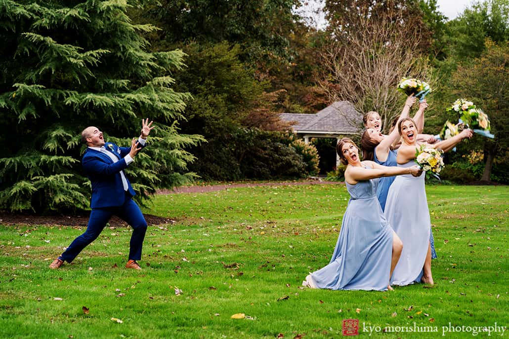 bridesmaids in blue dress and suit having fun holding bouquets in a field at Fall The Inn at Fernbrook Farm Chesterfield NJ Wedding