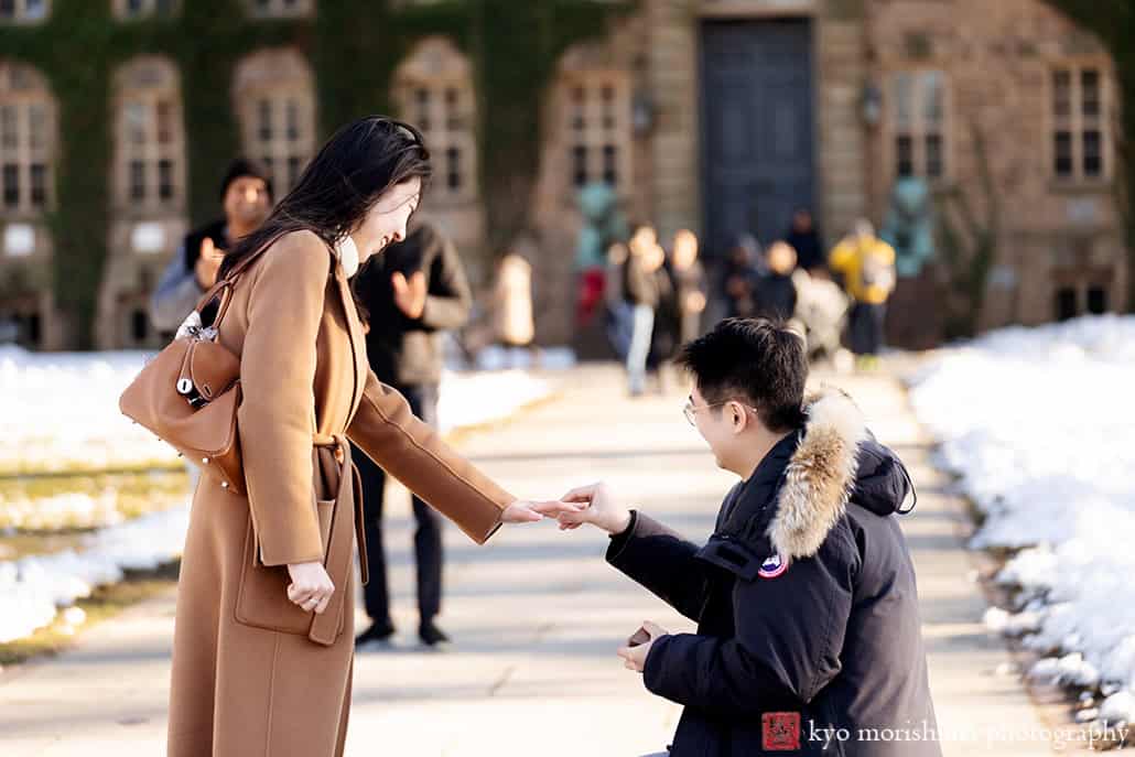 winter snow proposal portrait Nassau Hall Princeton University NJ NYC couple on his knee she said yes putting a rind on her finger