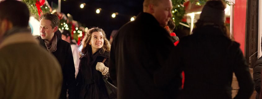Holding hands together at a holiday market string lights at dusk Central Park NYC