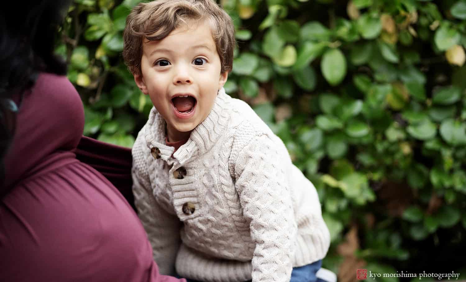 boy white sweater smiling princeton university nj family portrait baby sister on the way