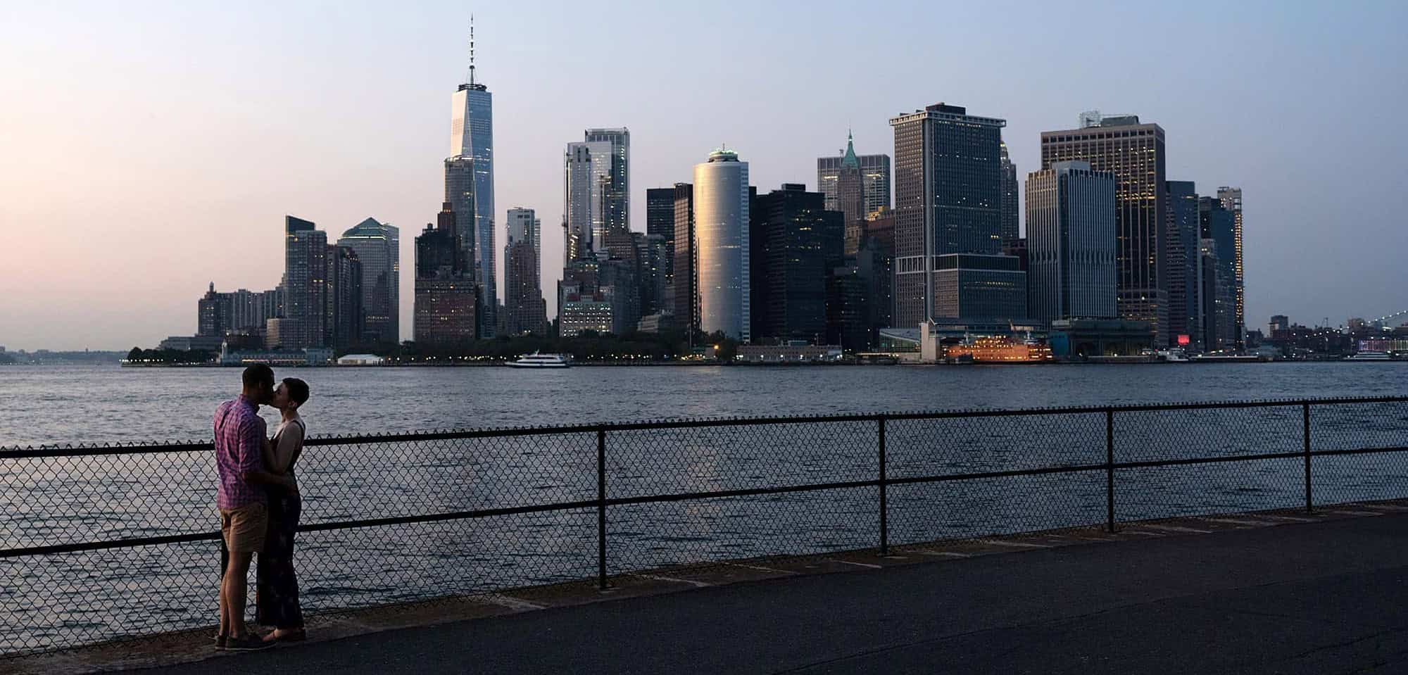 governors island engagement portrait photo cycling bike velo couple engaged nyc fun smile skyscraper city
