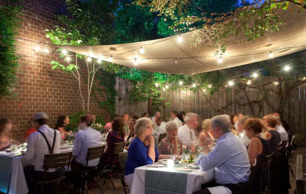 wedding family and friends having fun smiling at outdside backyard reception table cheers Frankies 457 Spuntino